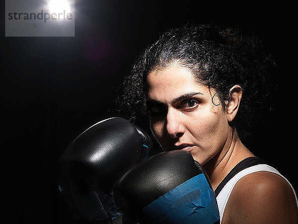 Porträt einer Boxerin vor schwarzem Hintergrund
