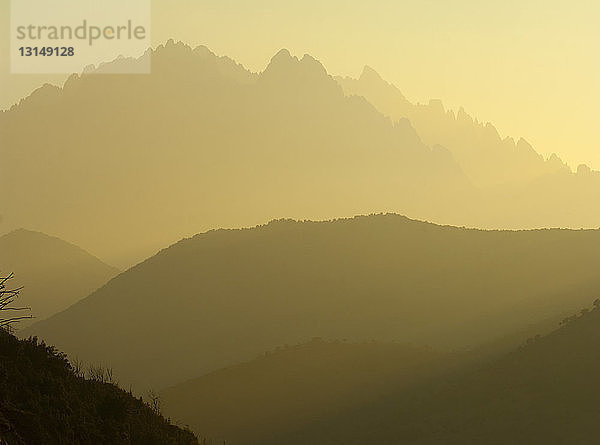 Silhouettierte neblige Berge bei Sonnenuntergang  Korsika  Frankreich