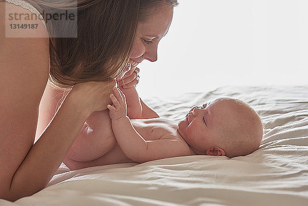 Mutter und kleines Mädchen von Angesicht zu Angesicht lächelnd