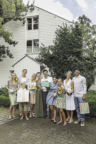 Porträt einer dreiköpfigen Familie mit Geburtstagsgeschenken im Garten