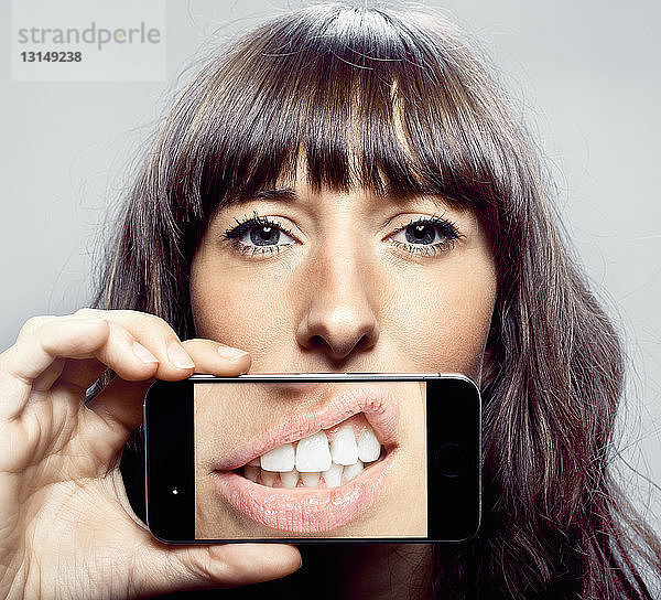 Frau mit Handybild vom Mund