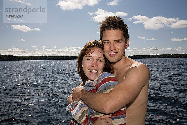 Paar umarmt neben dem See