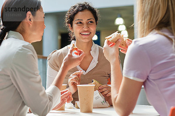 Büroangestellte genießen eine Mahlzeit im Bürocafé