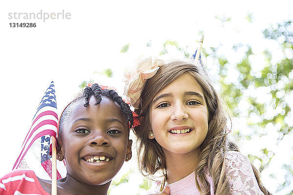 Porträt eines Mädchens mit amerikanischer Flagge im Park