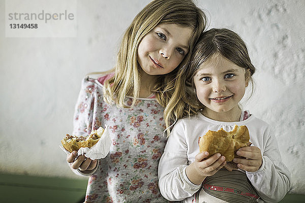 Zwei junge Mädchen essen ein herzhaftes Brötchen