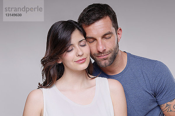 Porträt eines heterosexuellen Paares  zusammen stehend  Augen geschlossen