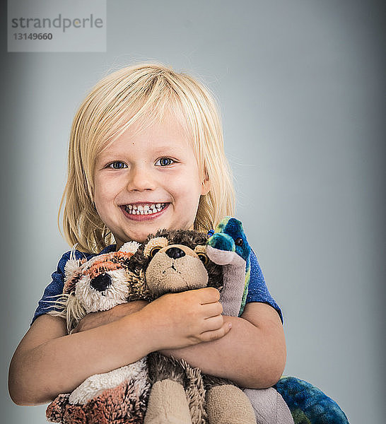 Porträt eines kleinen Jungen mit Kuscheltieren