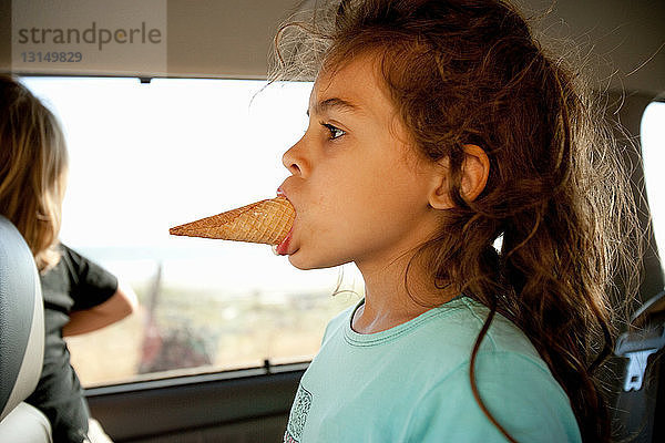 Junges Mädchen mit Eiswaffel im Mund