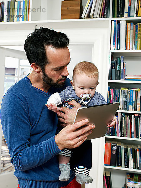 Vater zeigt Baby digitales Tablet