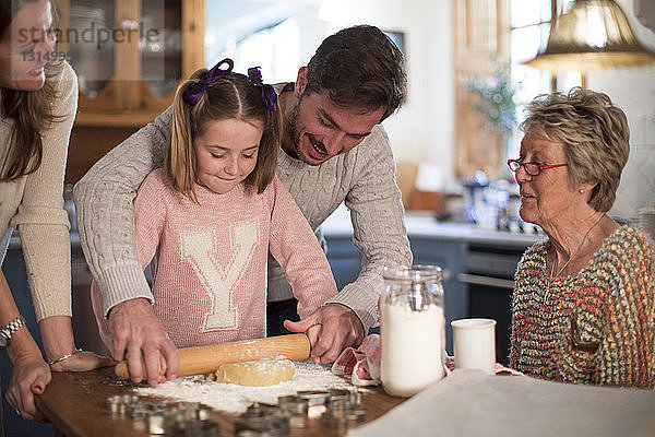 Vater und Tochter rollen Teig für selbstgebackene Kekse