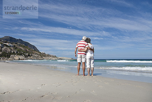 Älteres Paar umarmt sich am Strand