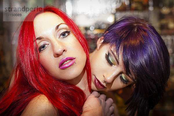 Porträt von zwei posierenden Freundinnen mit roten und lila Haaren