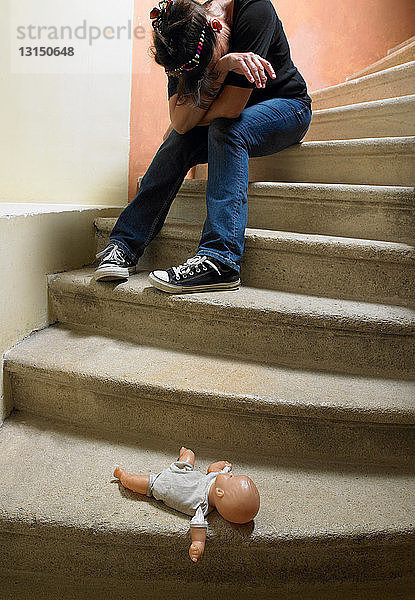 Puppe auf der Treppe  traurige Frau