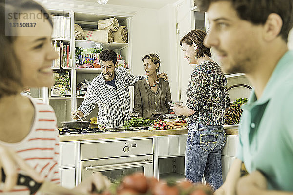 Fünf erwachsene Freunde versammeln sich zu einer Dinnerparty in der Küche