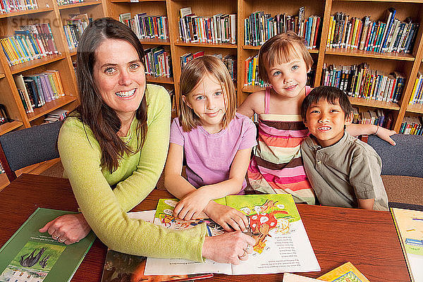 Schüler und Lehrer in der Schulbibliothek