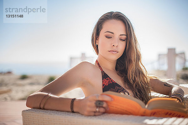 Junge Frau liest ein Buch am Strand  Castiadas  Sardinien  Italien