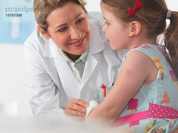 Kinderarzt  der sich um ein kleines Mädchen im OP kümmert