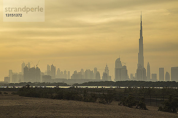 Blick auf den Burj Khalifa und die Skyline der Stadt bei Sonnenaufgang  Dubai