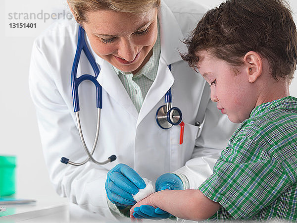 Arzt kümmert sich um verletzten kleinen Jungen