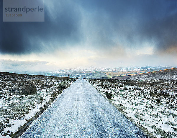 Eisige Landstraße mit Gewitterwolken  Swaledale  Yorkshire  Großbritannien
