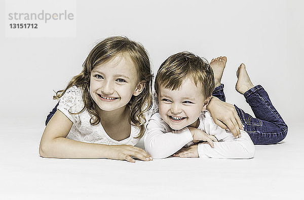 Bruder und Schwester auf dem Bauch liegend