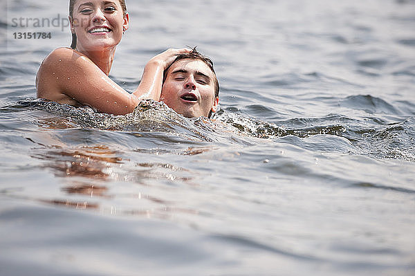 Junges Paar schwimmt im See