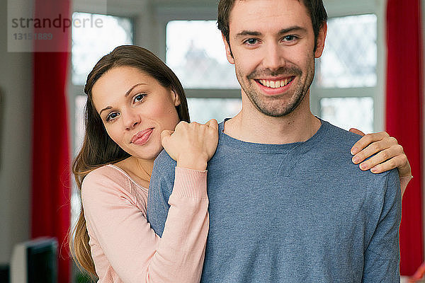 Porträt eines jungen Paares  Frau mit Händen auf den Schultern des Mannes