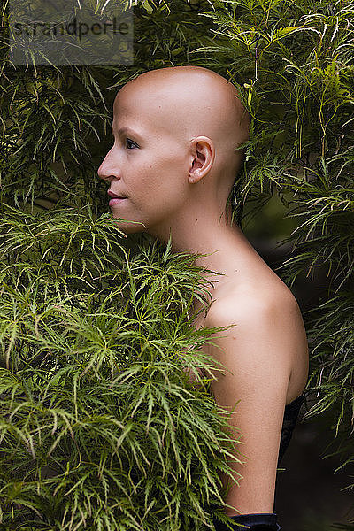 Seitenansicht Porträt einer jungen Frau mit Krebs im Laub