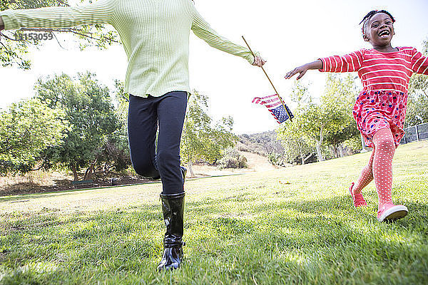 Kinder spielen mit amerikanischer Flagge im Park