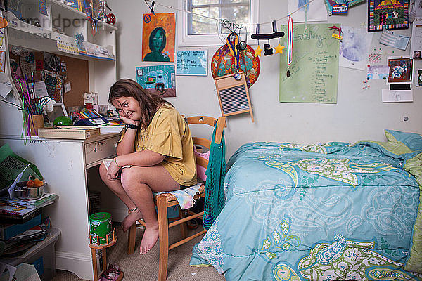 Porträt eines widerstrebenden Mädchens  das im Schlafzimmer ein Buch liest