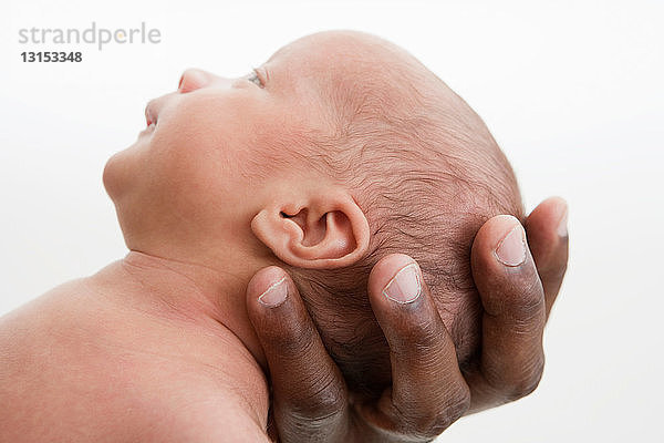 Vater hält den Kopf eines kleinen Babys