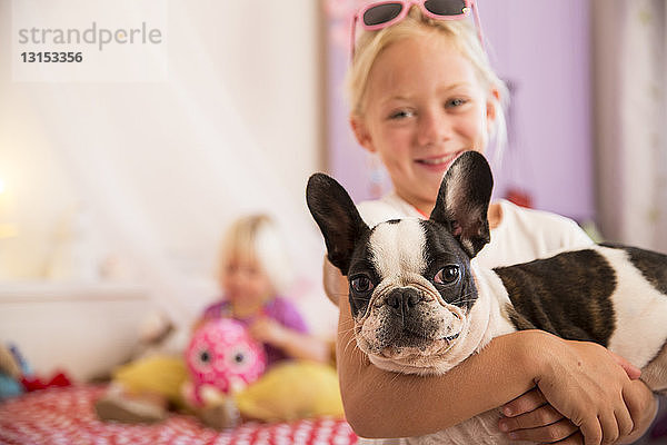 Porträt eines Mädchens und eines niedlichen Hundes im Schlafzimmer