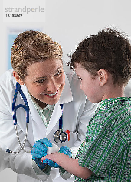 Arzt kümmert sich um verletzten kleinen Jungen