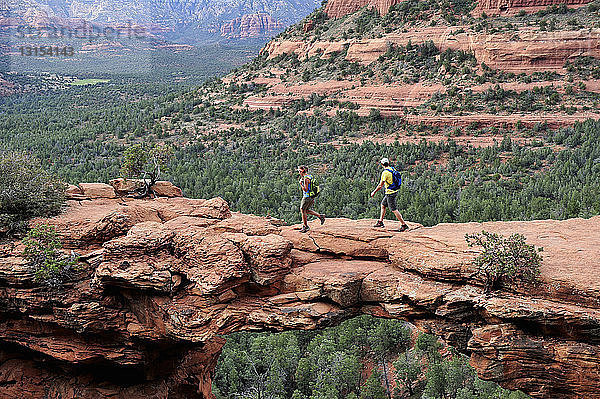Wanderndes Paar auf gewölbter Felsformation  Sedona  Arizona  USA