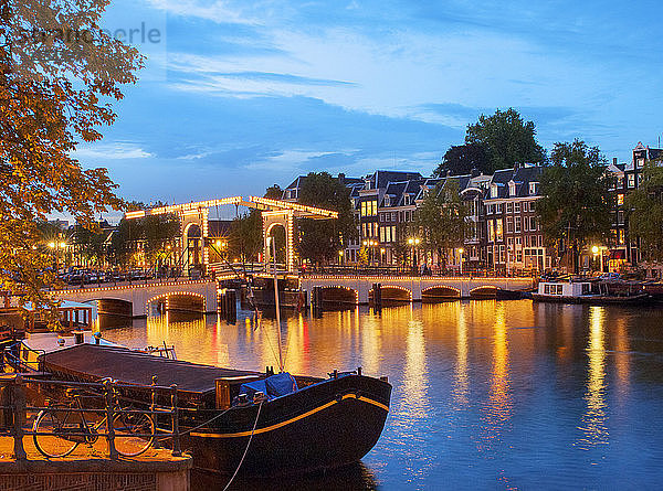 Die dünne Brücke in der Abenddämmerung beleuchtet  Amsterdam  Niederlande
