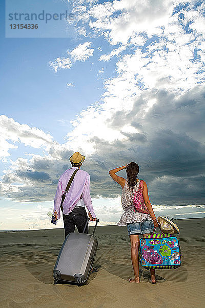 Reisendes Paar geht im Sand spazieren