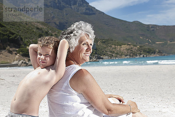 Ältere Frau mit Enkelsohn am Strand