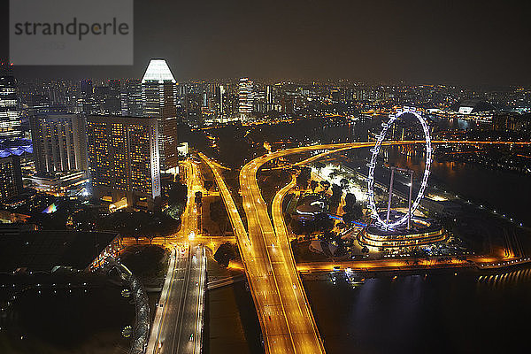 Stadtansicht von Riesenrad und Autobahn bei Nacht  Singapur