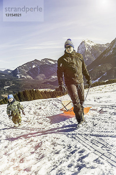 Mann  der einen Schlitten auf Schnee zieht  Achenkirch  Tirol  Österreich