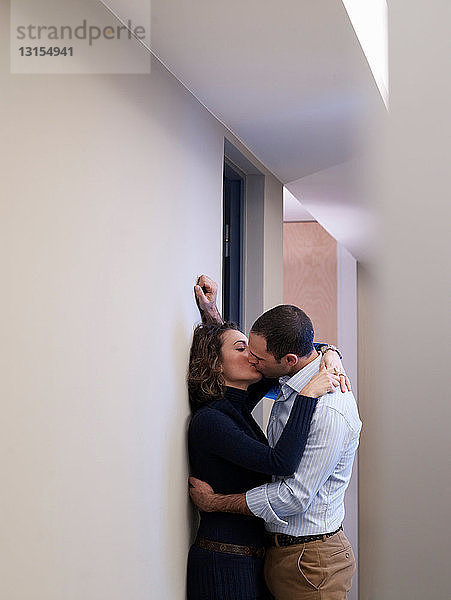 Paar küsst sich in einem Büroflur