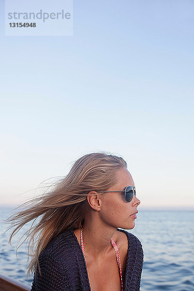 Frau mit Sonnenbrille auf einem Segelboot