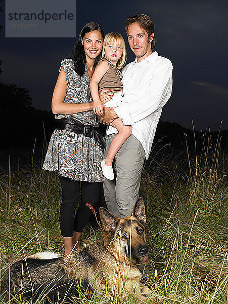 Familie mit Hund auf einem Feld  bei Nacht