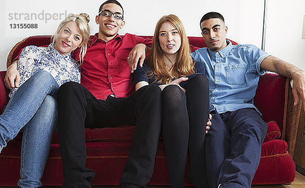 Vier junge Erwachsene sitzen auf einem Sofa