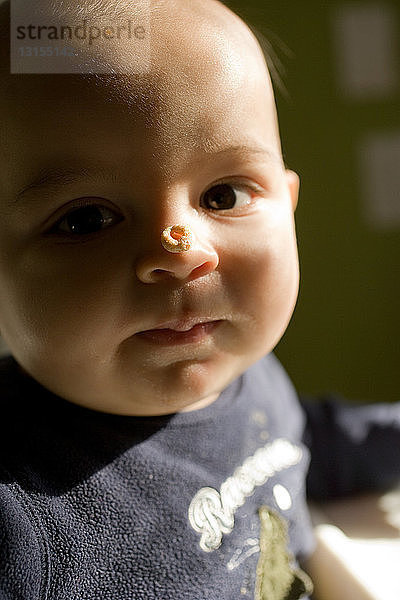 Kleiner Junge mit Frühstücksflocken auf der Nase