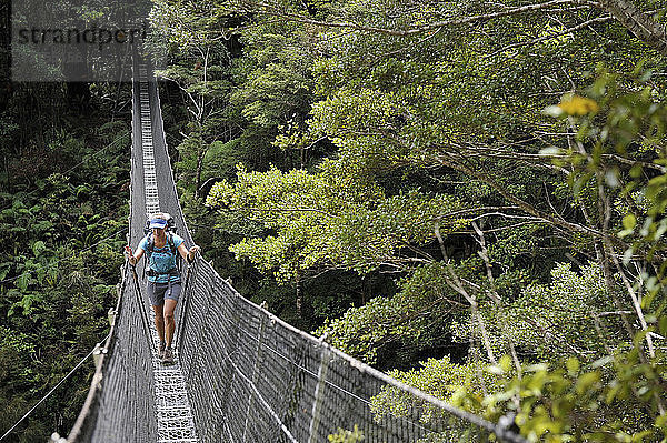 Wanderin überquert Fußgängerbrücke  Tararua Ridge  Neuseeland