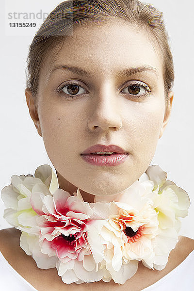 Studio-Porträt einer schönen jungen Frau mit Blumenkette