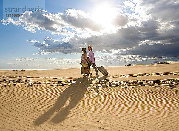 Reisendes Paar  das auf Sand geht