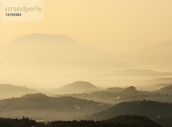 Silhouettiertes nebliges Tal bei Sonnenuntergang  Sardinien  Italien