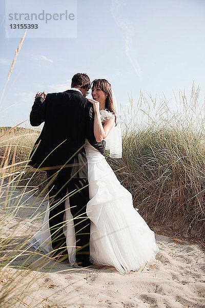 Braut und Bräutigam tanzen am Strand
