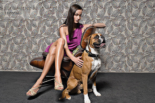 Frau sitzend auf Stuhl mit Hund